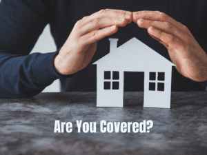 House graphic with hands over it representing insurance coverage.